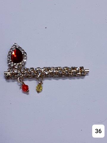 GOLDEN 2''TILAK SHAPED WITH RED BIG STONE AND FULL OF TINY STONES.